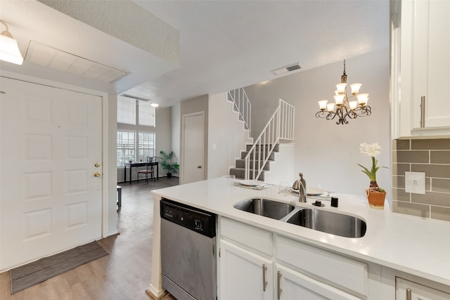 kitchen with sink, decorative light fixtures, stainless steel dishwasher, and white cabinets