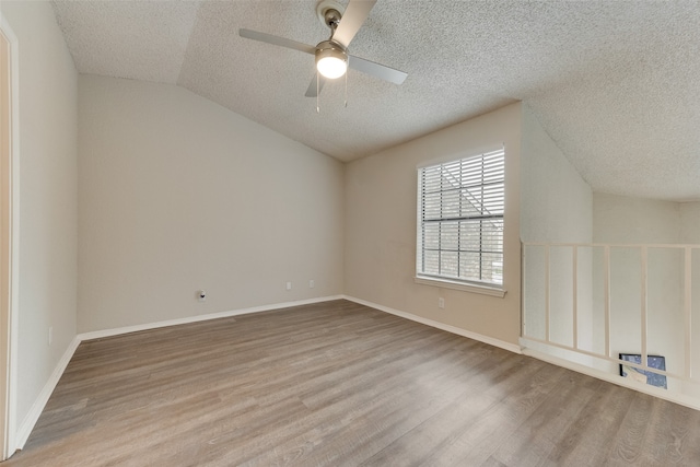 additional living space featuring light hardwood / wood-style floors, ceiling fan, a textured ceiling, and vaulted ceiling