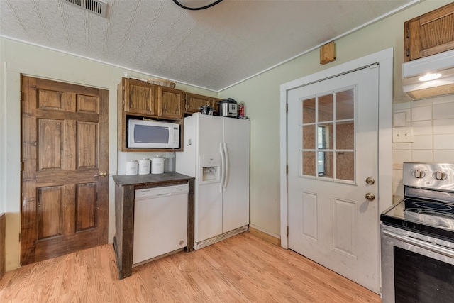 kitchen featuring decorative backsplash, white appliances, exhaust hood, and light hardwood / wood-style flooring