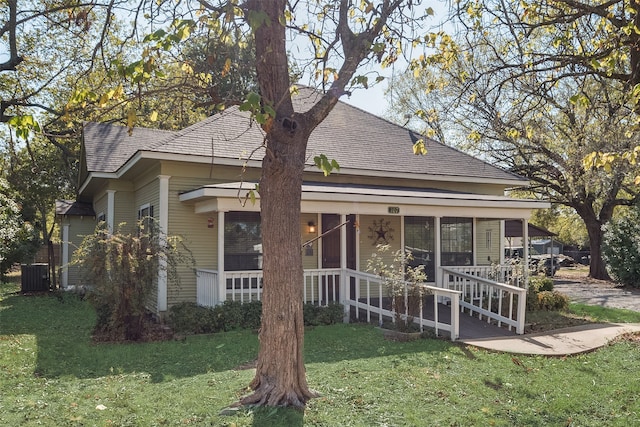 rear view of property featuring a porch and a lawn