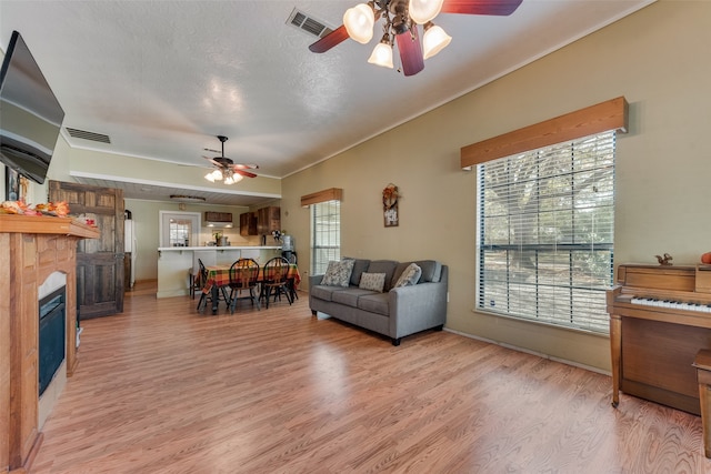 living room featuring ceiling fan, crown molding, and light wood-type flooring