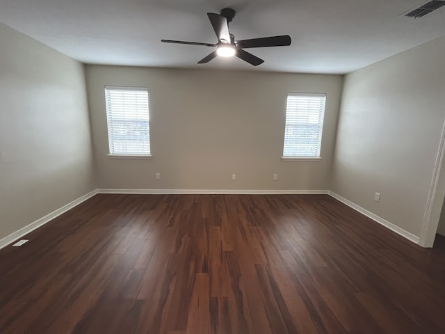 spare room with plenty of natural light, ceiling fan, and dark hardwood / wood-style flooring