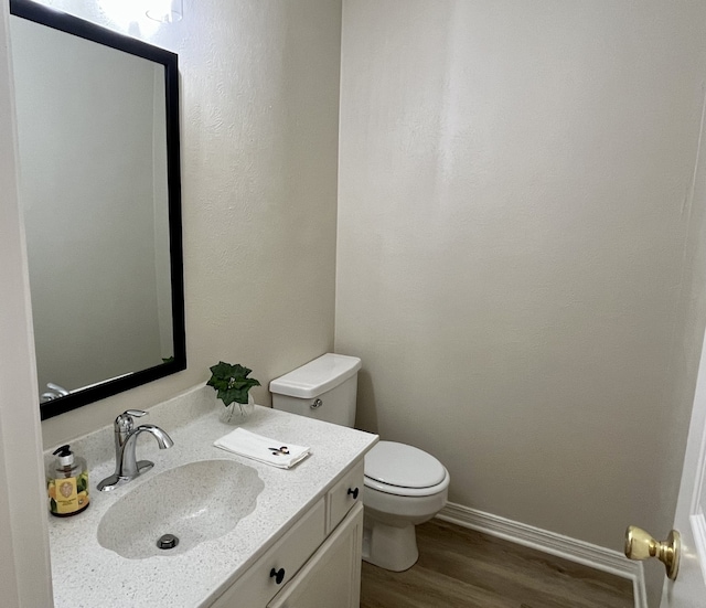 bathroom with hardwood / wood-style floors, vanity, and toilet