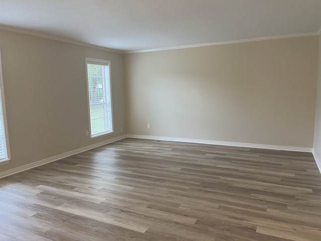 spare room featuring crown molding and hardwood / wood-style floors