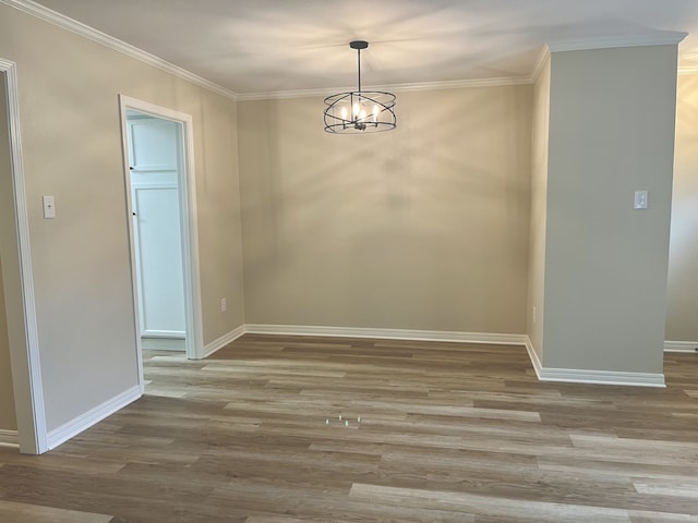 unfurnished dining area with wood-type flooring, a notable chandelier, and ornamental molding