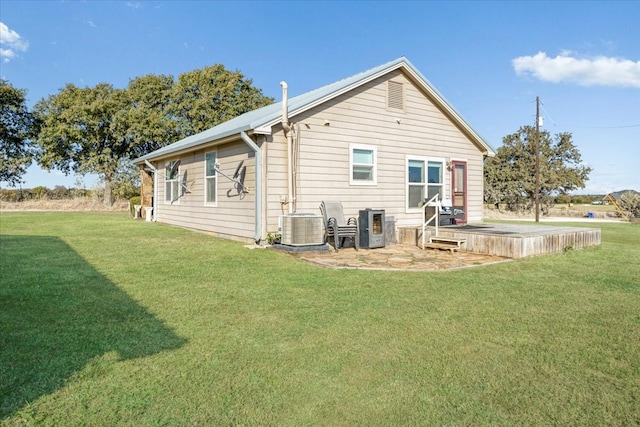 back of house featuring a lawn and cooling unit