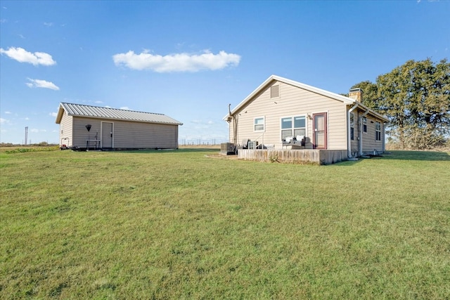 back of property featuring a yard and an outdoor structure