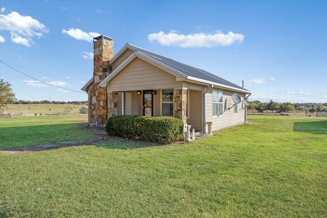 view of property exterior with a rural view and a yard