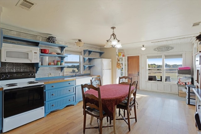 kitchen with decorative light fixtures, tasteful backsplash, white appliances, and light hardwood / wood-style flooring