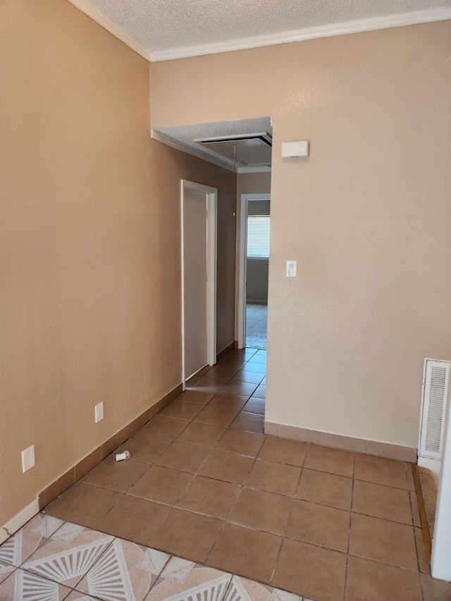 tiled spare room featuring crown molding and a textured ceiling