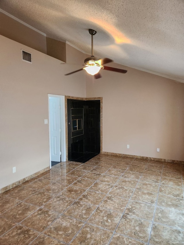 empty room with ceiling fan, high vaulted ceiling, and a textured ceiling