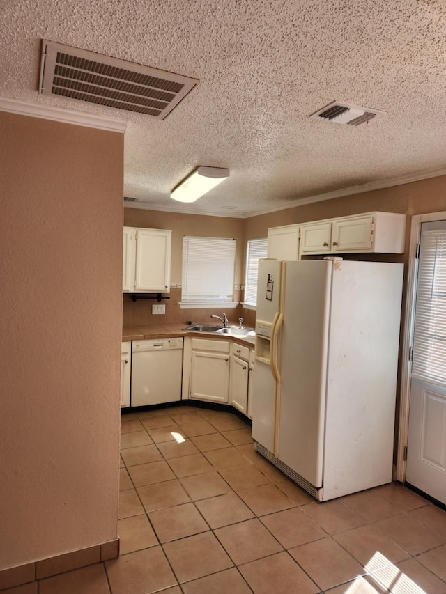 kitchen with sink, crown molding, light tile patterned floors, white cabinets, and white appliances