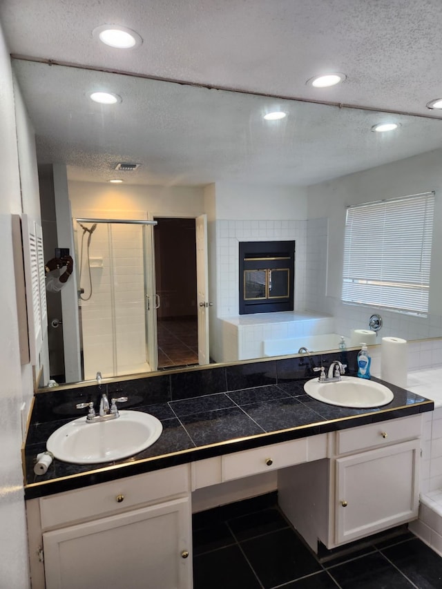 bathroom featuring vanity, separate shower and tub, a tile fireplace, and tile patterned flooring