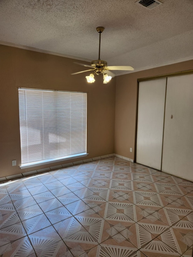 unfurnished bedroom featuring light tile patterned floors, a textured ceiling, a closet, and ceiling fan