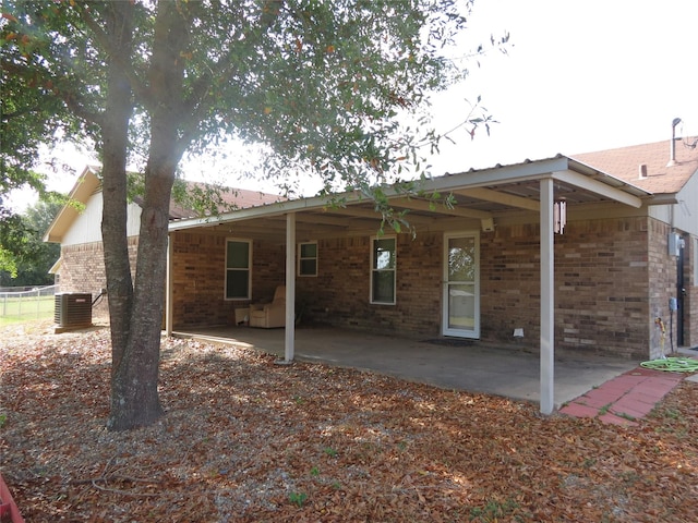 back of property with central AC and a patio area