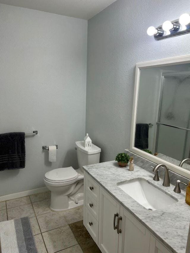 bathroom featuring toilet, an enclosed shower, tile patterned flooring, and vanity