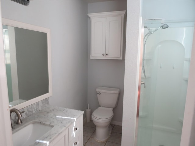 bathroom featuring toilet, vanity, tile patterned floors, and walk in shower