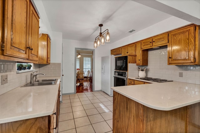 kitchen featuring kitchen peninsula, sink, light tile patterned flooring, black appliances, and pendant lighting