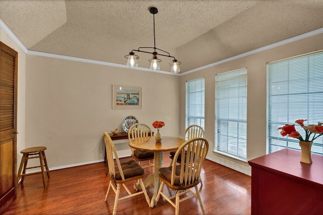 dining room featuring crown molding, hardwood / wood-style floors, and lofted ceiling