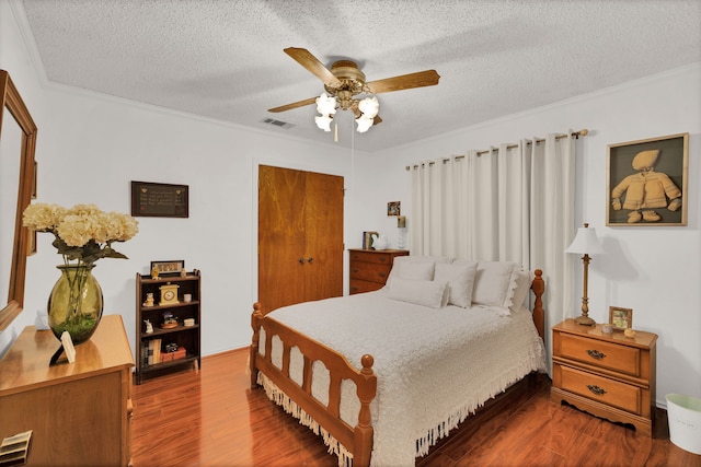 bedroom featuring crown molding, a textured ceiling, wood-type flooring, and ceiling fan