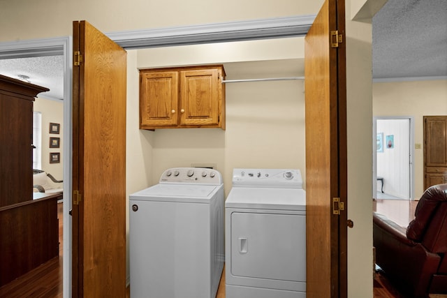 washroom with cabinets, independent washer and dryer, a textured ceiling, and crown molding