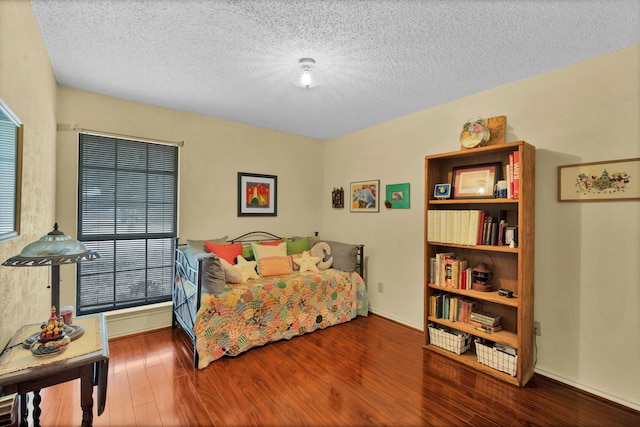 bedroom with a textured ceiling and hardwood / wood-style flooring