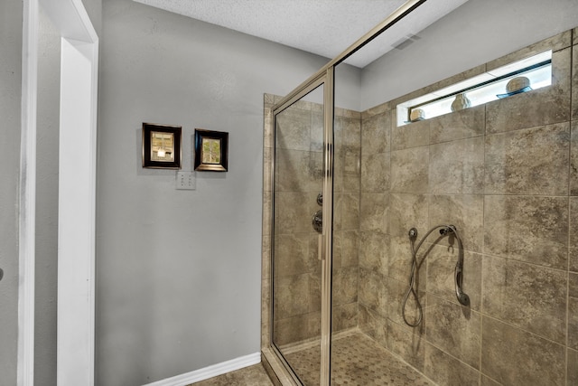 bathroom featuring a textured ceiling and walk in shower