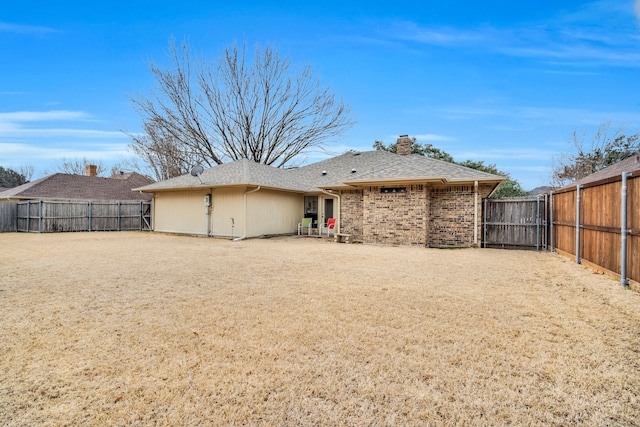 rear view of property featuring a patio and a lawn