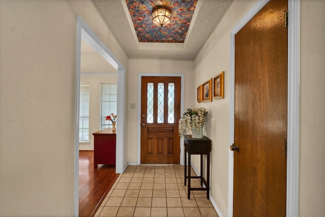 foyer entrance with a textured ceiling and light wood-type flooring