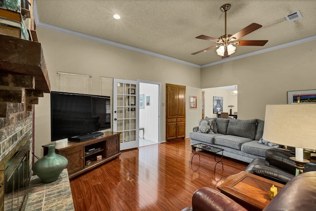 living room featuring dark wood-type flooring, a textured ceiling, and ornamental molding