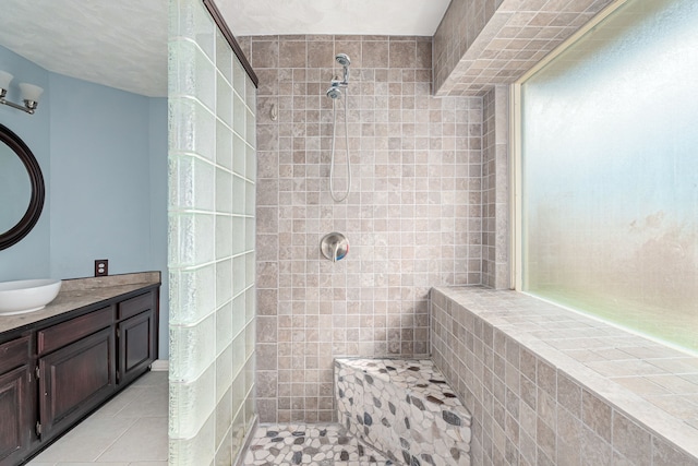 bathroom with vanity, tiled shower, and tile patterned floors