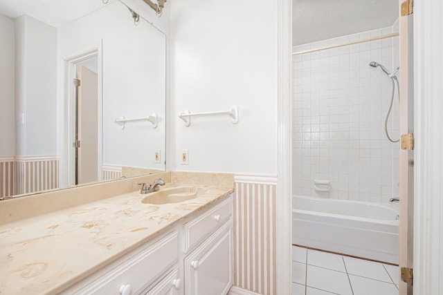 bathroom with vanity, tiled shower / bath, a textured ceiling, and tile patterned flooring