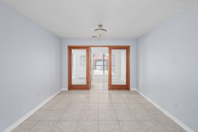 entryway with a textured ceiling and light tile patterned flooring