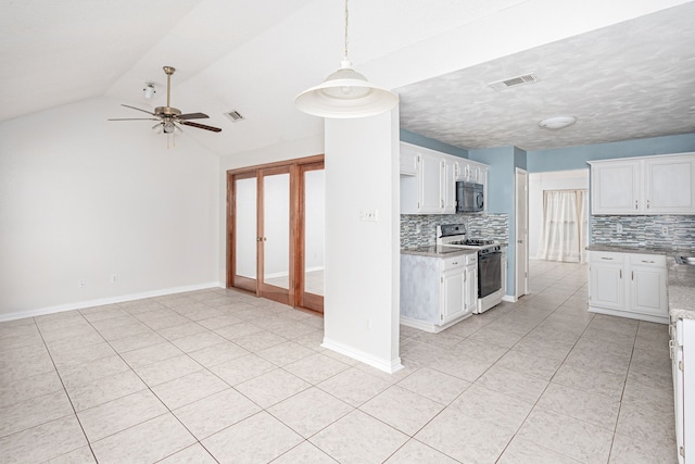 kitchen with white gas stove, tasteful backsplash, lofted ceiling, and white cabinets