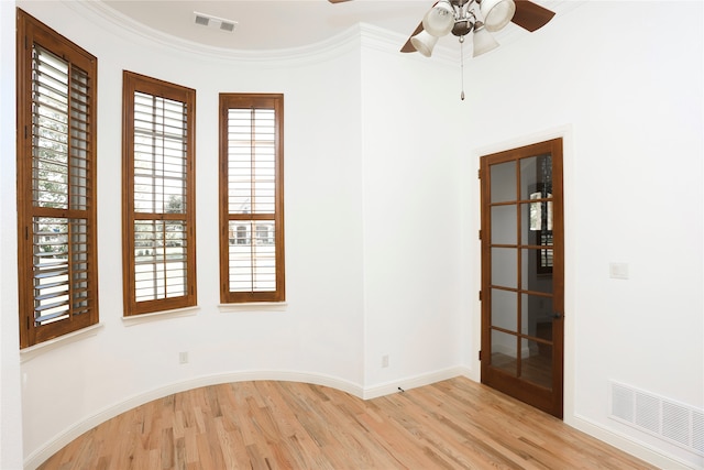 empty room with ceiling fan, light hardwood / wood-style floors, and ornamental molding