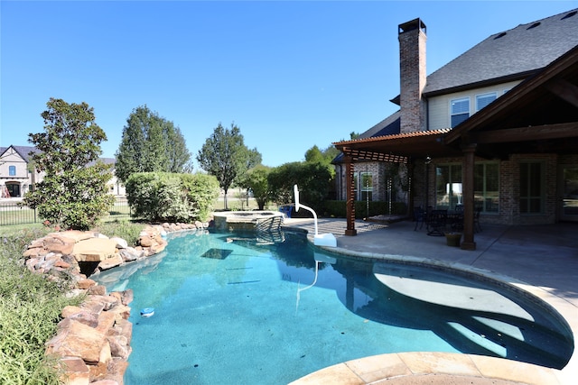 view of pool with a patio area and an in ground hot tub