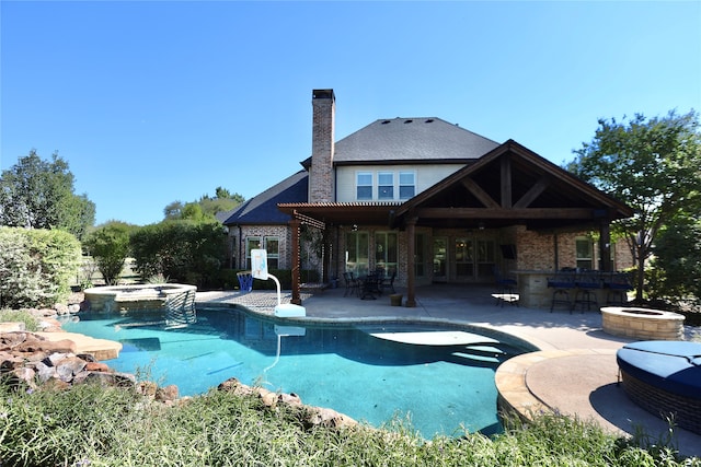 view of pool featuring a bar, an in ground hot tub, and a patio