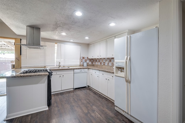 kitchen featuring white cabinets, kitchen peninsula, white appliances, and extractor fan