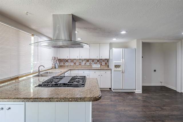 kitchen featuring island exhaust hood, dark wood-type flooring, white refrigerator with ice dispenser, stainless steel gas stovetop, and white cabinetry