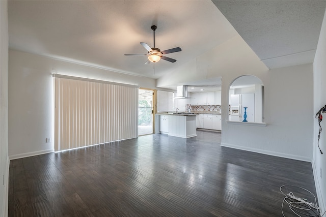 unfurnished living room featuring sink, ceiling fan, vaulted ceiling, and dark hardwood / wood-style floors