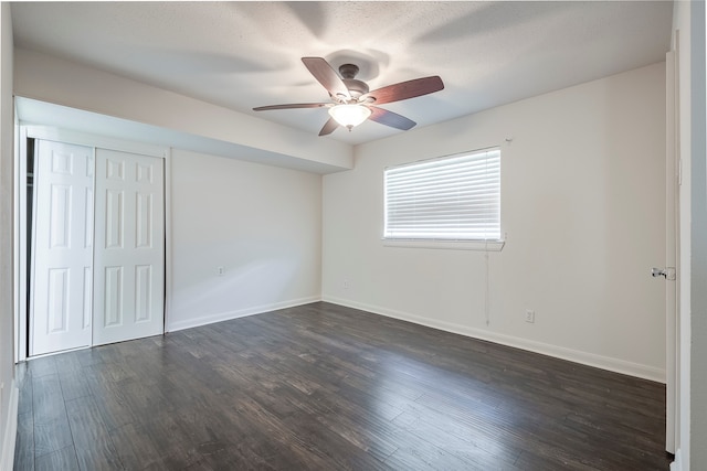 unfurnished bedroom featuring dark hardwood / wood-style flooring, a textured ceiling, a closet, and ceiling fan