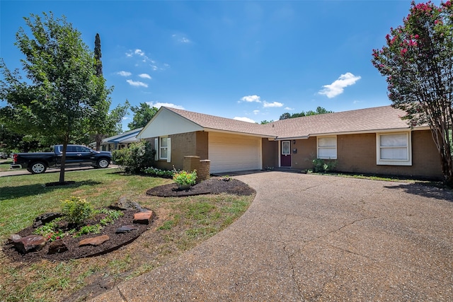 ranch-style house featuring a front yard and a garage