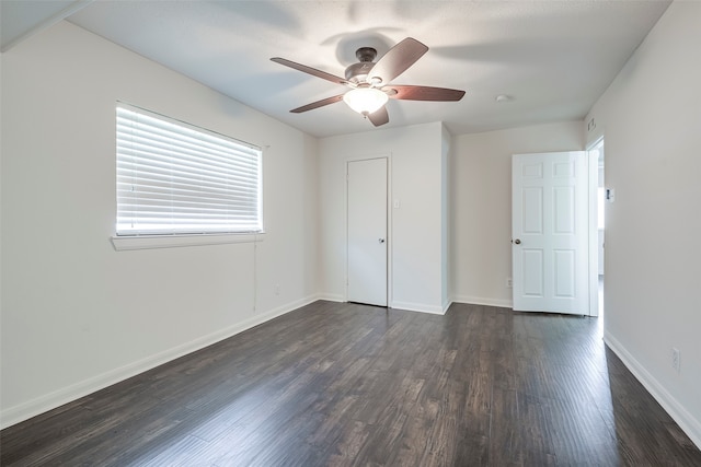 unfurnished bedroom featuring dark wood-type flooring, a closet, and ceiling fan