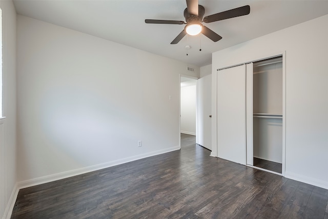 unfurnished bedroom with dark hardwood / wood-style flooring, a closet, and ceiling fan