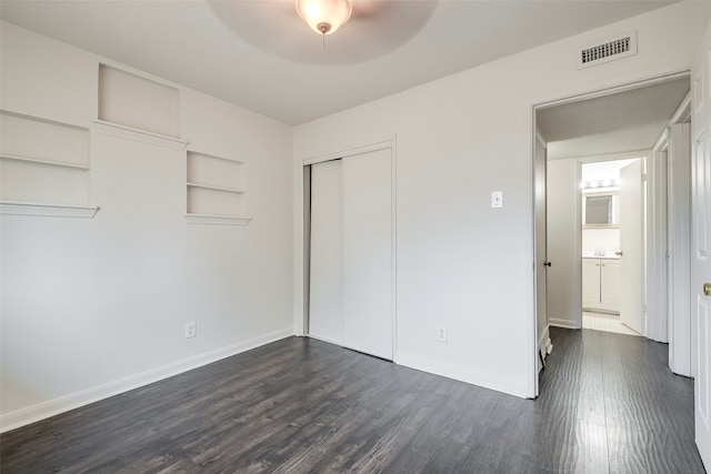 unfurnished bedroom featuring a closet, dark hardwood / wood-style floors, and ceiling fan