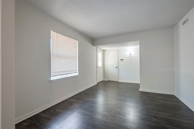 unfurnished room with a textured ceiling and dark hardwood / wood-style flooring