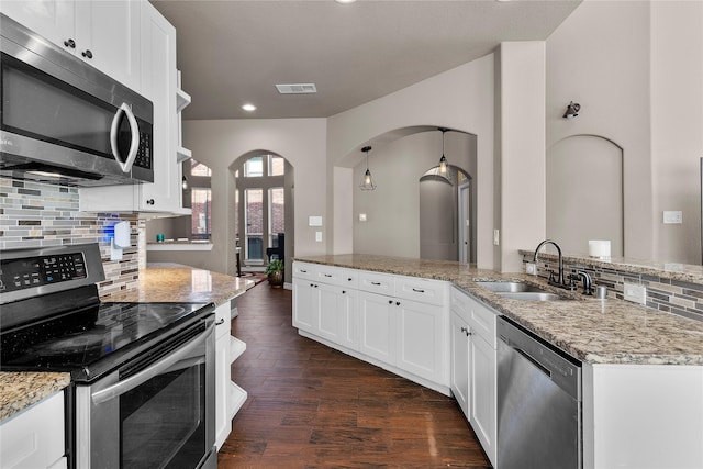 kitchen with white cabinets, appliances with stainless steel finishes, sink, and light stone counters