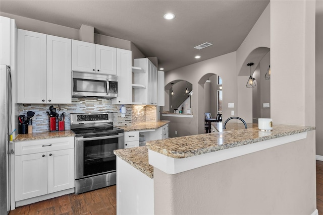 kitchen with appliances with stainless steel finishes, decorative backsplash, dark hardwood / wood-style floors, white cabinets, and light stone counters