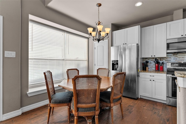 dining room with dark hardwood / wood-style floors, a wealth of natural light, and an inviting chandelier