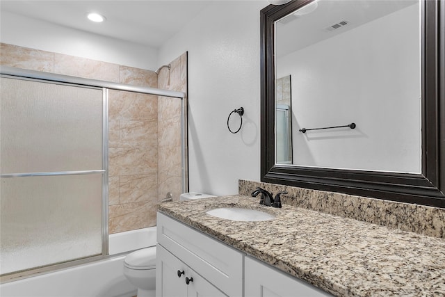 full bathroom featuring toilet, enclosed tub / shower combo, and vanity